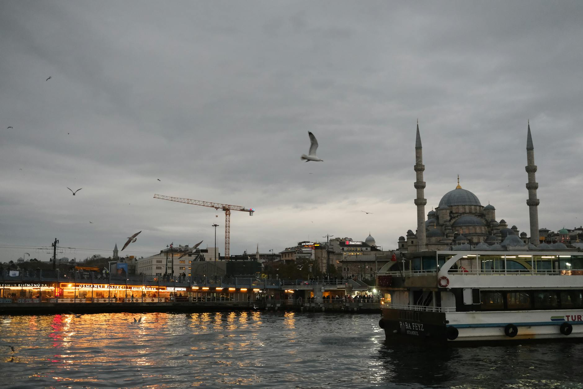 해 질 녘 에미뇌뉘 부두에 정박한 페리와 그 뒤로 보이는 이스탄불 도시 전경.