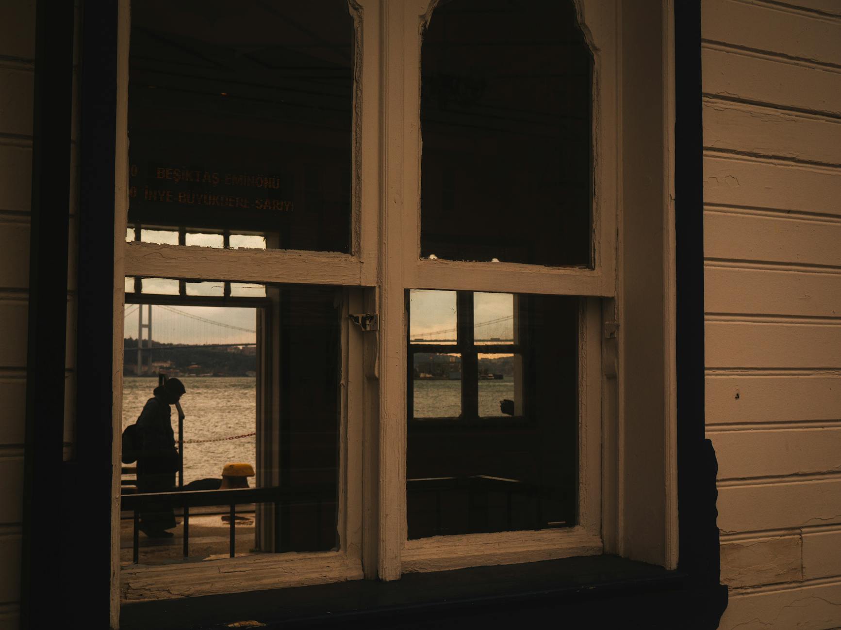 페리 터미널 창문을 통해 본 보스포루스 해협과 다리 실루엣