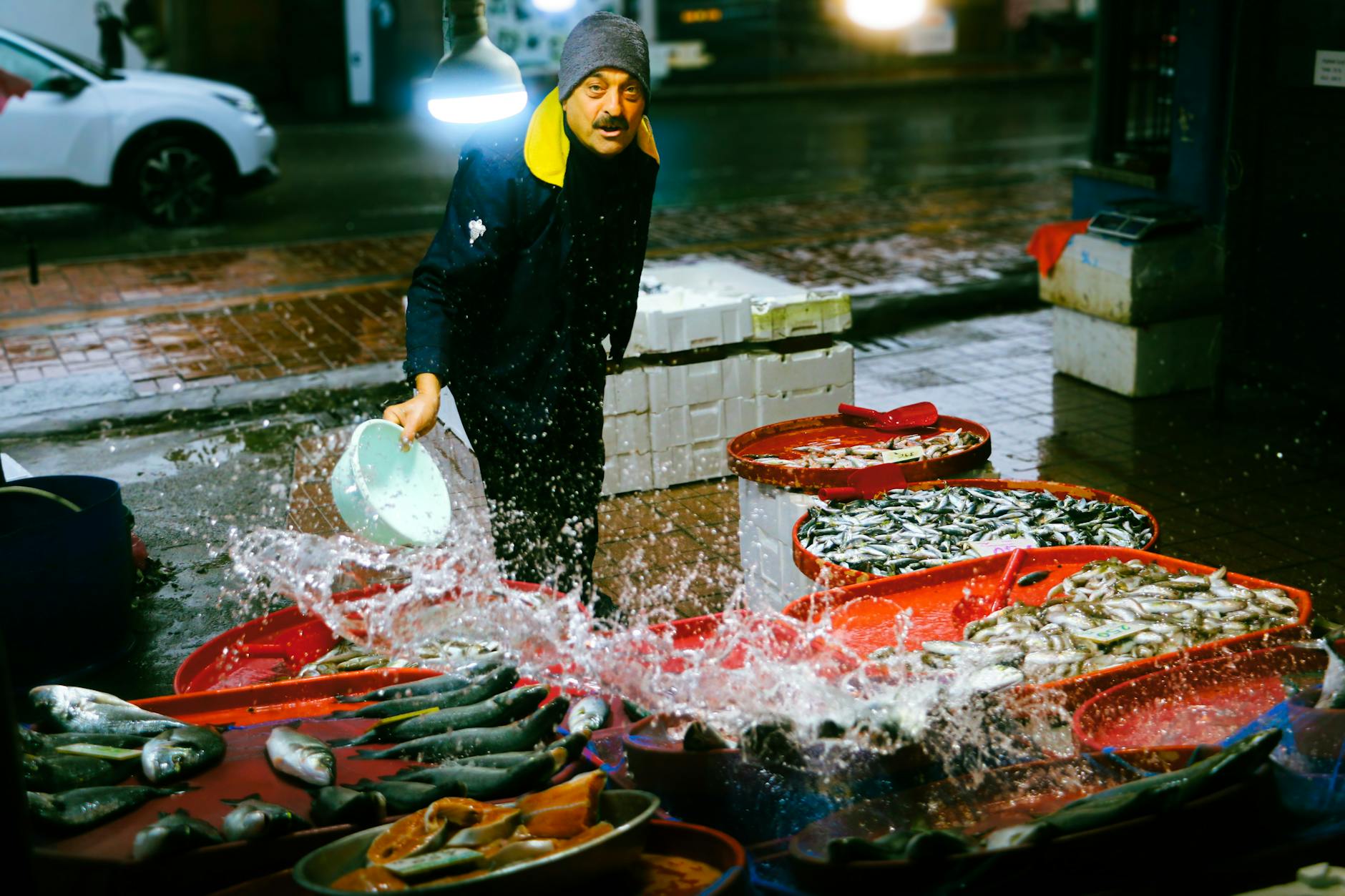 이스탄불 수산시장에서 상인이 갓 잡은 신선한 생선 위에 시원하게 물을 뿌리고 있다.