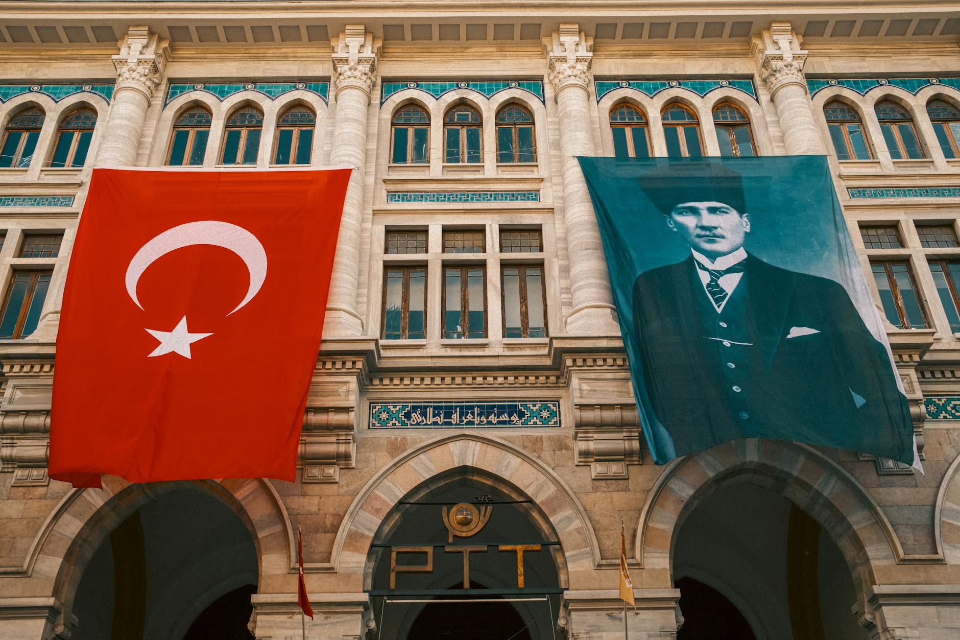 터키 국기와 아타튀르크 초상이 걸려 있는 웅장한 이스탄불 중앙 우체국 건물입니다.