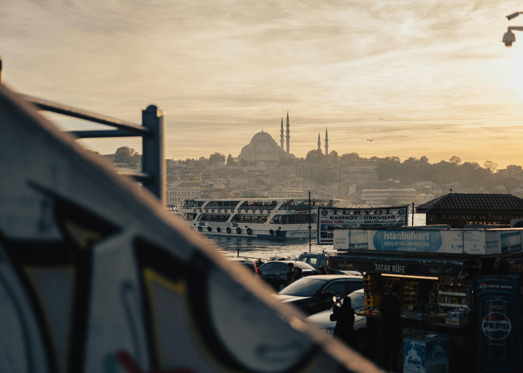 이스탄불 시내의 이스탄불카르트 충전소 너머로 쉴레이마니예 모스크와 페리가 보입니다.