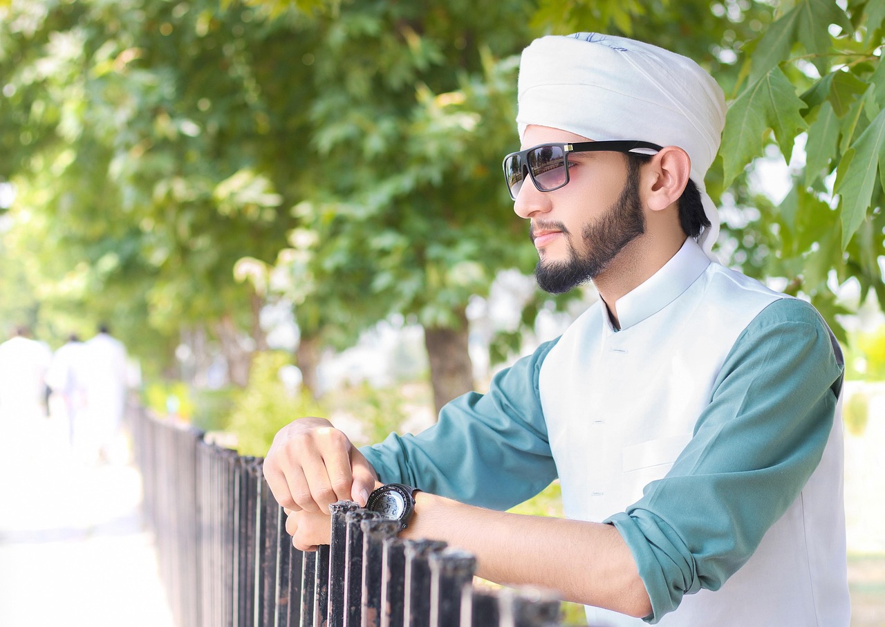 라마단 기간 금식 종료 시간을 기다리며 시계를 확인하는 전통 의상 남성